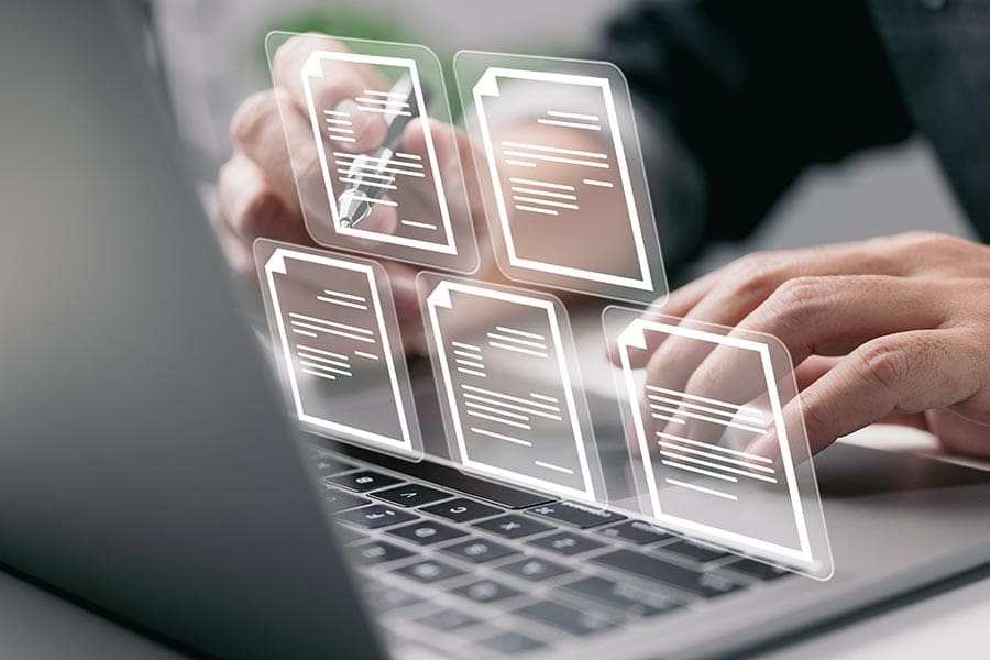 Fingers typing on a computer with a virtual display of icons.